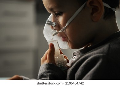 Home treatment. The boy makes inhalation with a nebulizer inhaling medicines into his lungs. Self-treatment of the respiratory tract with inhalation.