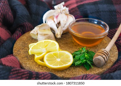 Home Treatment Kit For Flu And Seasonal Colds. Lemon, Mint, Honey, Ginger And Garlic On Wooden Tray On Scarf