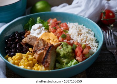 Home Version Of A Burrito Bowl. Contains Grilled Chicken, Black Beans, Corn, Guacamole, Queso,  Salsa, Sour Cream And Rice On A Bed Of Romaine Lettuce.