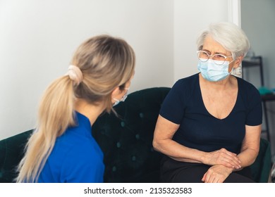 Home Visit Concept. Masked Senior Explaining Her Health Problems To Her Primary Care Physician Lady. . High Quality Photo