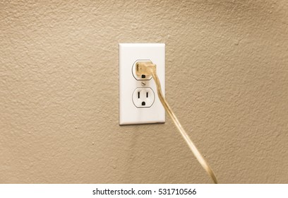 Home Wall Outlet With Cable Plugged In.