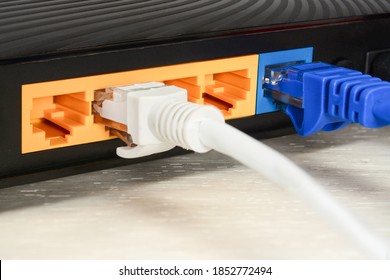 Home Wi-fi Router For Internet Connection With Patch Cords And Two Connectors. Concept Home Network, Closeup On White Wooden Table.