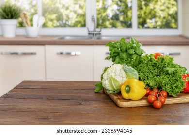 Home wooden kitchen table with various fresh food vegetables for healthy and diet eating with space for your product or text - Powered by Shutterstock