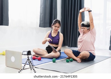 Home Workout Concept, Asian Teenage And Elderly Women Exercising, Looking At Tablet And Laptop. And Shoot Video As Well.