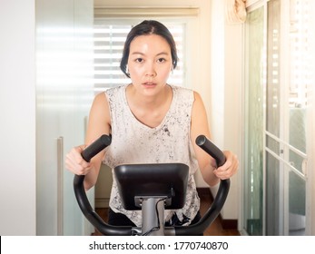 Home Workout Indoor Stationary Bike Asian Girl Biking Screen With Online Classes Woman Training On Smart Fitness. 