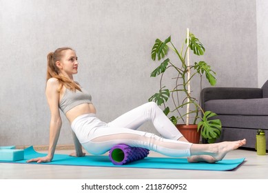 Home Workout. Young Woman Massage Thigh Muscle With Foam Massage Roller. Equipment For Myofascial Release.