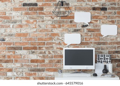 Home Workspace With Small Desk, Computer And Brick Wall