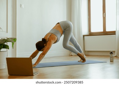 At Home Yoga Practice A Woman Performing the Downward Dog Pose in a Tranquil Space - Powered by Shutterstock