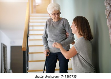 Homecare Helping Elderly Woman Going Down The Stairs