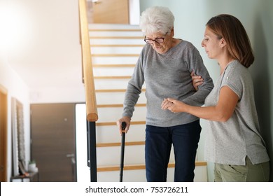 Homecare Helping Elderly Woman Going Down The Stairs