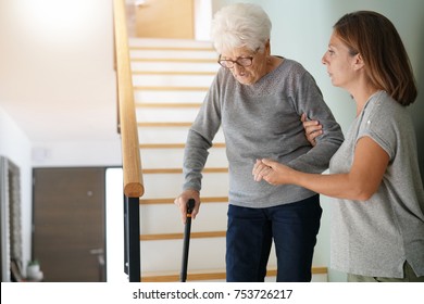 Homecare Helping Elderly Woman Going Down The Stairs