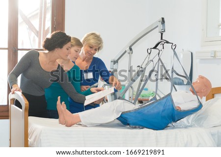 homecare nurses hoisting a dummy