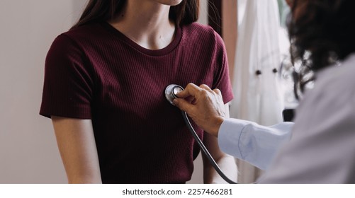 Homecare nursing service and elderly people cardiology healthcare. Close up of young hispanic female doctor nurse check mature caucasian man patient heartbeat using stethoscope during visit - Powered by Shutterstock