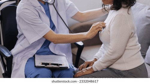 Homecare nursing service and elderly people cardiology healthcare. Close up of young hispanic female doctor nurse check mature caucasian man patient heartbeat using stethoscope during visit - Shutterstock ID 2332048617