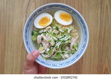 Home-cooked Japanese instant ramen with boiled egg, chicken meat and scallions. Top view image.
