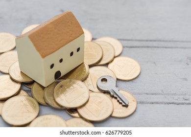 Home,key and golden coins on wooden background,properties concept