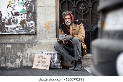 Homeless Beggar Man Sitting Outdoors In City Asking For Money Donation.