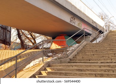 Homeless camps with tents and tarp shelter under a bridge