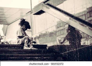 Homeless child eating on the stairway in the street. September - 16. 2016. Novi Sad, Serbia. Editorial image. 