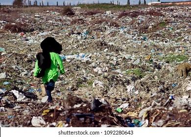 A Homeless Child Is Playing In A Garbage Dump
