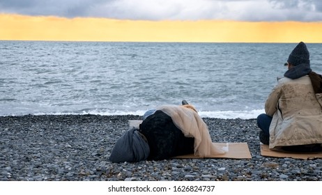 homeless couple, man and woman, staying overnight by the sea. - Shutterstock ID 1626824737