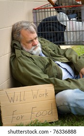 Homeless and hopeless man in an old army jacket waits for a handout.