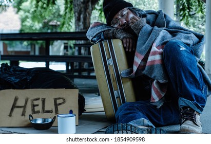 A Homeless, Impacted By The Coronavirus Man Asks For Money Or Food Help From Passers-by On The Street Side With A Help Sign.