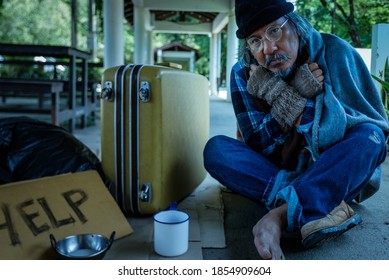 A Homeless, Impacted By The Coronavirus Man Asks For Money Or Food Help From Passers-by On The Street Side With A Help Sign.