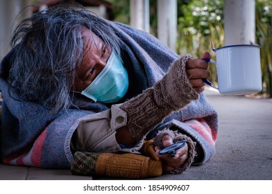 A Homeless, Impacted By The Coronavirus Man Asks For Money Or Food Help From Passers-by On The Street Side With A Help Sign.