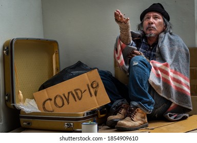 A Homeless, Impacted By The Coronavirus Man Asks For Money Or Food Help From Passers-by On The Street Side With A Help Sign.