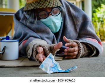 A Homeless, Impacted By The Coronavirus Man Asks For Money Or Food Help From Passers-by On The Street Side With A Help Sign.