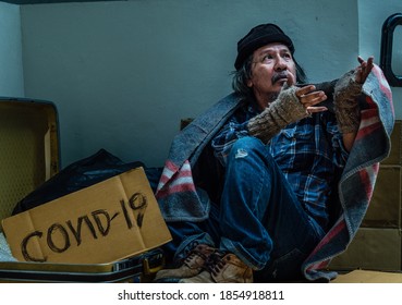 A Homeless, Impacted By The Coronavirus Man Asks For Money Or Food Help From Passers-by On The Street Side With A Help Sign.