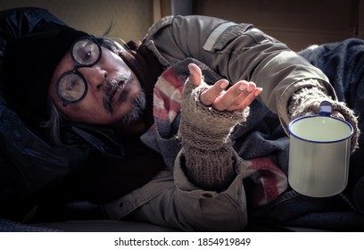 A Homeless, Impacted By The Coronavirus Man Asks For Money Or Food Help From Passers-by On The Street Side With A Help Sign.