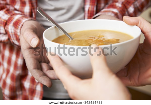 Homeless Man
Being Handed Bowl Of Soup By
Volunteer