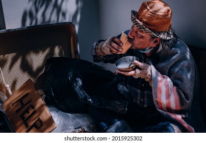 Homeless Man With Help Sign Enjoys Eating As Someone Made A Food Donation.