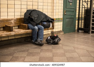 Homeless Man Sleeping On The Bench In New York City Subway Station Covered By Own Coat