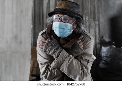 Homeless Man Wearing Medical Face Mask For Health Sitting And Cold In An Abandoned Building