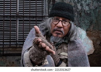 Homeless Old Man Reaching Out To Passerby Ask For Money, Need For Help, Poverty Man No Home Meet Financial Crisis Ask For Food Live On Sidewalk. Donate And Charity Concept.