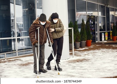 Homeless In A Winter City. Man Asking For Food. Girl Helping A Homeless. People In A Medical Masks.