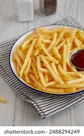 Homemade American French Fries with Ketchup on a Plate, side view. 