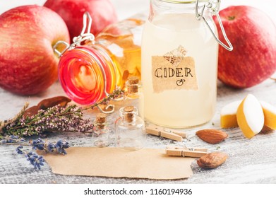 Homemade apple cider and fresh apples on wooden table