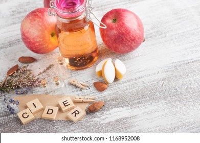 Homemade apple cider and fresh apples on wooden table