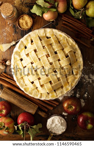 Homemade apple pie with lattice ready to be baked on a rustic background