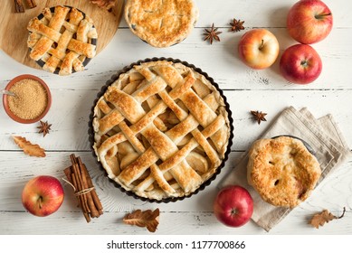 Homemade Apple Pies On White Wooden Background, Top View. Classic Autumn Thanksgiving Dessert - Organic Apple Pie.