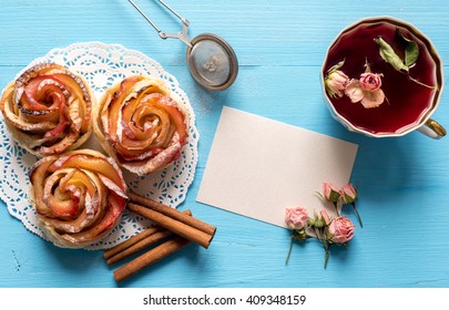 Homemade Apple rose cake with sugar powder on blue  wooden background.
Top view.  Handmade gift for mom/ Mother's day greeting card. - Powered by Shutterstock