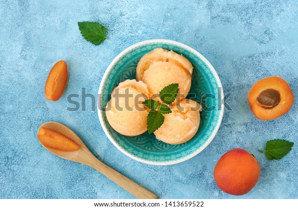 Homemade apricot ice cream , sorbet\
with ripe apricots and mint leaves. Top view                \
