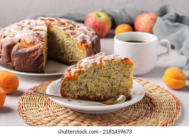 Homemade apricots pie with poppy seeds and apples, with cup of coffee on gray background