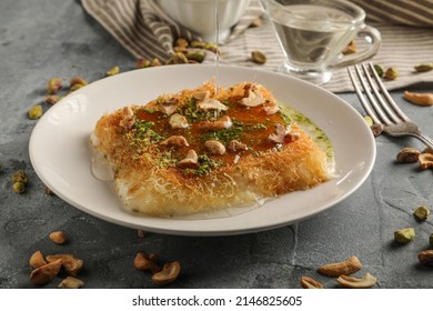 Homemade arabian traditional sweets Kunafa or konafa nuts on top, cheese and sugar syrup, on tray