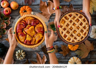 Homemade Autumn Pies At The Hands Of Two Women. Overhead View Of An Apple Pie, A Pumpkin Pie And A Peach Pie