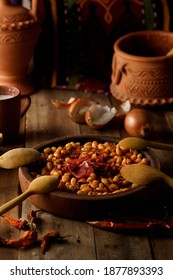 Homemade baked beans with bacon in  earthenware pot with wooden spoon - Shutterstock ID 1877893393